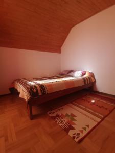 a bed in a room with a wooden ceiling at Apartment Zlatibor Vesna in Zlatibor