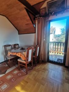 een eetkamer met een tafel en stoelen en een groot raam bij Apartment Zlatibor Vesna in Zlatibor