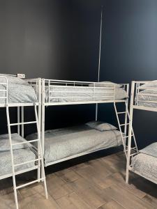 three bunk beds in a room with a wall at Rio Hostel in Madrid