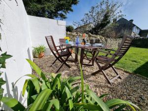 a wooden table and two chairs in a garden at Church View - 2 bed Cosy Cottage in Swanage in Swanage