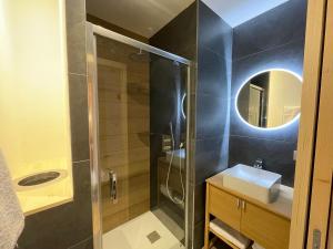 W łazience znajduje się prysznic, umywalka i lustro. w obiekcie Chalet Clos du Nant Megève w mieście Demi-Quartier