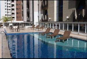 a swimming pool with chairs and tables in a building at FLAT 1417 in Águas Claras