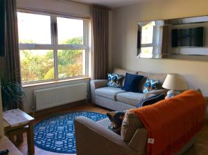 a living room with a couch and two windows at Apiary Mews in Newcastle