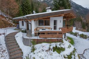 una casa en la nieve con un patio cubierto de nieve en Chalet Hinterstein en Scheffau am Wilden Kaiser