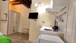 uma cozinha com um lavatório e uma televisão na parede em Appartamento Mughetto em Florença