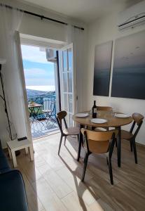 a dining room with a table and chairs and a balcony at Sull'Onda in Scalea