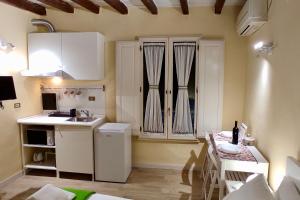 een kleine keuken met een wastafel en een tafel bij Appartamento Mughetto in Florence