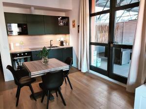 een keuken met een tafel en stoelen en een keuken met een raam bij Nuovo Loft con terrazzo M2 IEO Humanitas Bocconi Navigli in Milaan