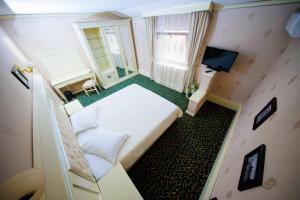 Kleines Zimmer mit einem Bett und einem TV in der Unterkunft Cazare Plopii fara Sot in Iaşi