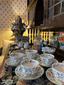 a table with cups and saucers on top of it at St. George Hotel in Barkerville