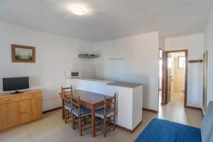 a kitchen and dining room with a table and a television at APARTAMENTOS CASA EUGENIO FORMENTERA in La Savina