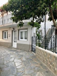 a house with a balcony and a stone walkway at Σπίτι με απεριόριστη θέα in Tríkeri