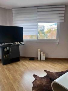 salon z telewizorem i dużym oknem w obiekcie Apartamento a 2 min de playa w mieście Calpe