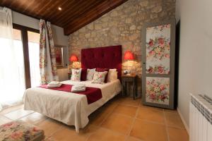 a bedroom with a bed and a stone wall at Casa Tapioles in Basella