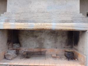 a stone fireplace with two benches and a barrel at TUNUYAN Apart in Tunuyán