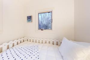 威爾明頓的住宿－Little Red，白色的卧室设有床和窗户
