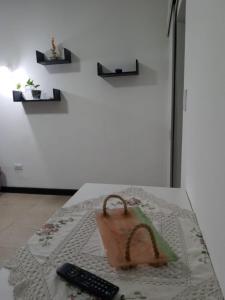 a table with a purse and a remote control at Monoambiente reciclado a nuevo zona Aldrey in Mar del Plata