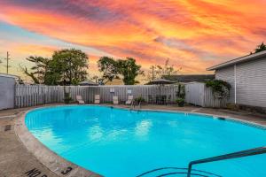 リホボスビーチにあるRehoboth Beach House --- 20494 Coastal Highway #15の夕日を背景に広い青いスイミングプール