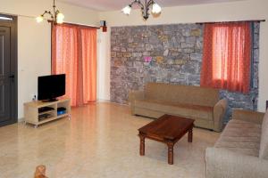 sala de estar con sofá y TV en Villa Niobe, en Riglia