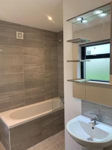 een badkamer met een wastafel en een bad bij Cheerful 3 bedroom cottage with great seaview in Drogheda