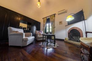 a living room with two chairs and a fireplace at Hotel El Potrerillo de Larreta in Alta Gracia