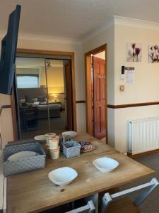 ein Wohnzimmer mit einem Holztisch und einem Kühlschrank in der Unterkunft Highland Stays - Rushfield House Rooms in Fort William