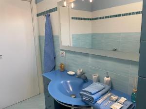 ein Badezimmer mit einem blauen Waschbecken und einem Spiegel in der Unterkunft Civita Home in Bagnoregio