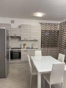 eine Küche mit einem weißen Tisch und weißen Stühlen in der Unterkunft Civita Home in Bagnoregio