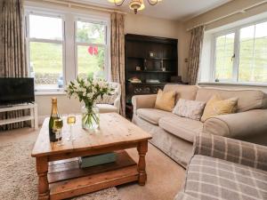 a living room with a couch and a table at Dales Cottage in Grassington