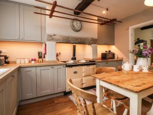 a kitchen with a wooden table and a dining room at Dales Cottage in Grassington