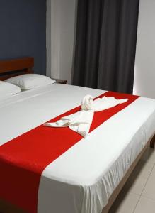 Una cama con una manta roja y blanca. en Hotel MCH, en Veracruz