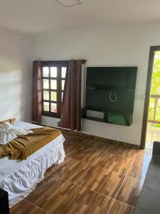 a bedroom with a bed and a wooden floor at Pousada Pipa Imperial in Pipa