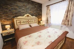 a bedroom with a bed and a brick wall at The Transylvanian Apartment - near Bridge ofLies in Sibiu