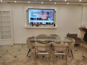 a dining room with a glass table and chairs and a screen at Villa Alice in Blérancourt