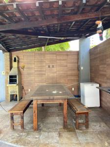 a picnic table with two benches and a refrigerator at Casa para temporada in João Pessoa