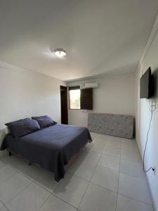 1 dormitorio con 1 cama y TV en Casa para temporada, en João Pessoa
