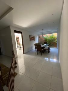 a dining room and living room with a table and chairs at Casa para temporada in João Pessoa