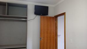 a room with a television on the corner of a wall at Apartamento Próx ao Centro com Wi-Fi e Estacionamento Grátis in Maringá