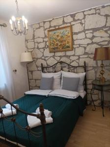 1 dormitorio con 1 cama con pared de piedra en Siedlisko Lubicz Stara Chata Kazimierz Dolny, en Kazimierz Dolny