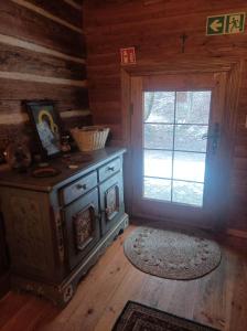 a room with a stove and a window in a cabin at Siedlisko Lubicz Stara Chata Kazimierz Dolny in Kazimierz Dolny