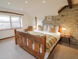 a bedroom with a bed and a stone wall at Maes Madog in Betws-y-coed +71 photos