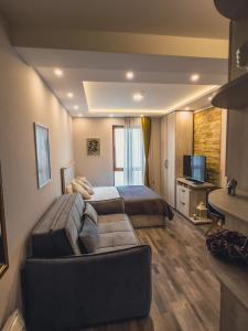 a hotel room with a bed and a couch at Milmari Premier - Daisy Apartments in Kopaonik