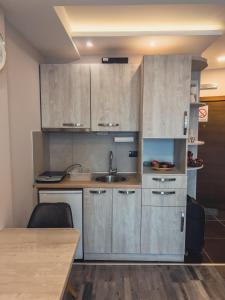 a kitchen with wooden cabinets and a sink at Milmari Premier - Daisy Apartments in Kopaonik