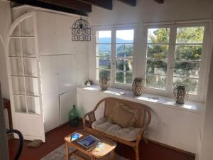 a living room with a chair and some windows at Hôtel Paradis in Bormes-les-Mimosas