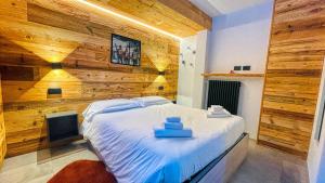a bedroom with a bed and a wooden wall at Appartamento Livia - Affitti Brevi Italia in Bardonecchia