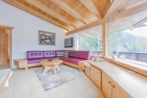 a living room with a purple couch and a table at Chalet Hinterstein in Scheffau am Wilden Kaiser