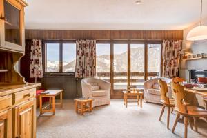 eine Küche und ein Wohnzimmer mit Blick auf die Berge in der Unterkunft Appartement LaForet 86 in La Tzoumaz