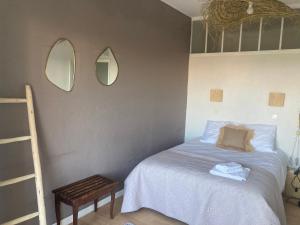 a bedroom with a bed and two mirrors on the wall at Hôtel Paradis in Bormes-les-Mimosas