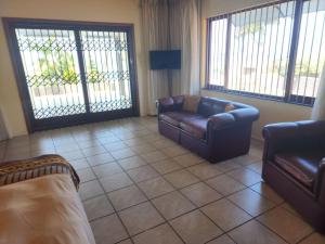 a living room with two leather couches and windows at Beach View in Oslo Beach