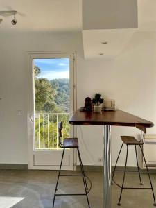 eine Küche mit einem Tisch, 2 Hockern und einem Fenster in der Unterkunft Vue panoramique - résidence calme - St Raphaël in Saint-Raphaël